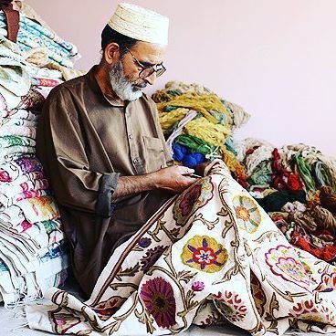 A Kashmiri artisan hand-embroidering a namda