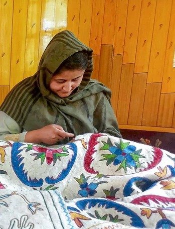 A Kashmiri artisan hand-embroidering a namda